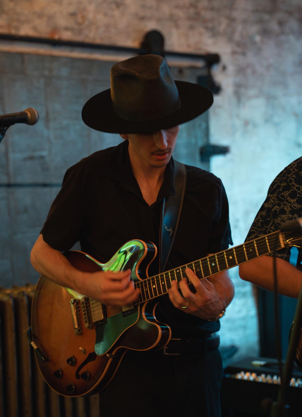 Ben Hulbert playing electric guitar in a wide-brimmed hat
