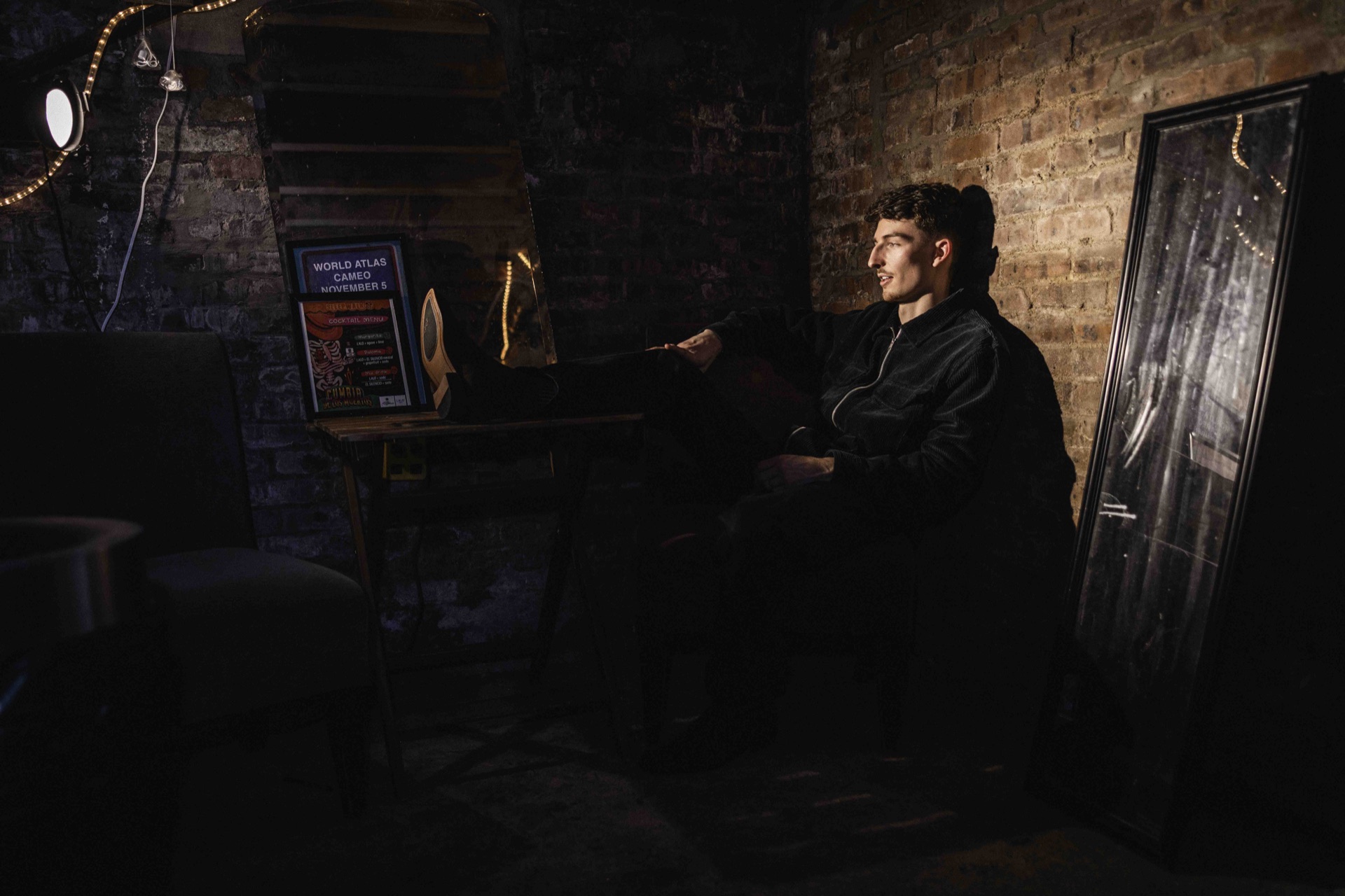 Ben Hulbert seated backstage against a brick wall